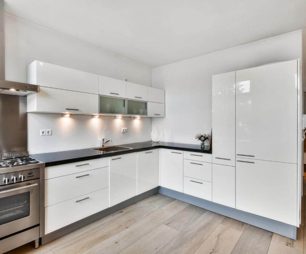 Reforma de cocina blanca en calle Doctor Robert, Reus Cocina moderna en forma de L con mobiliario blanco y electrodomésticos de acero inoxidable en Reus.
