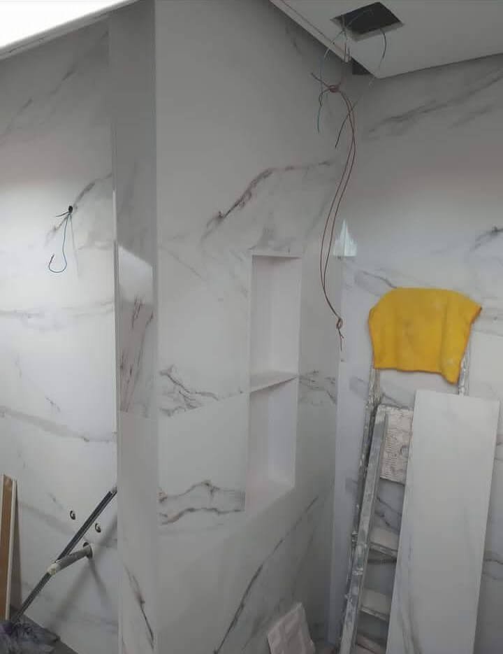 Reforma de lavabo en construcción con revestimiento de mármol en Reus.