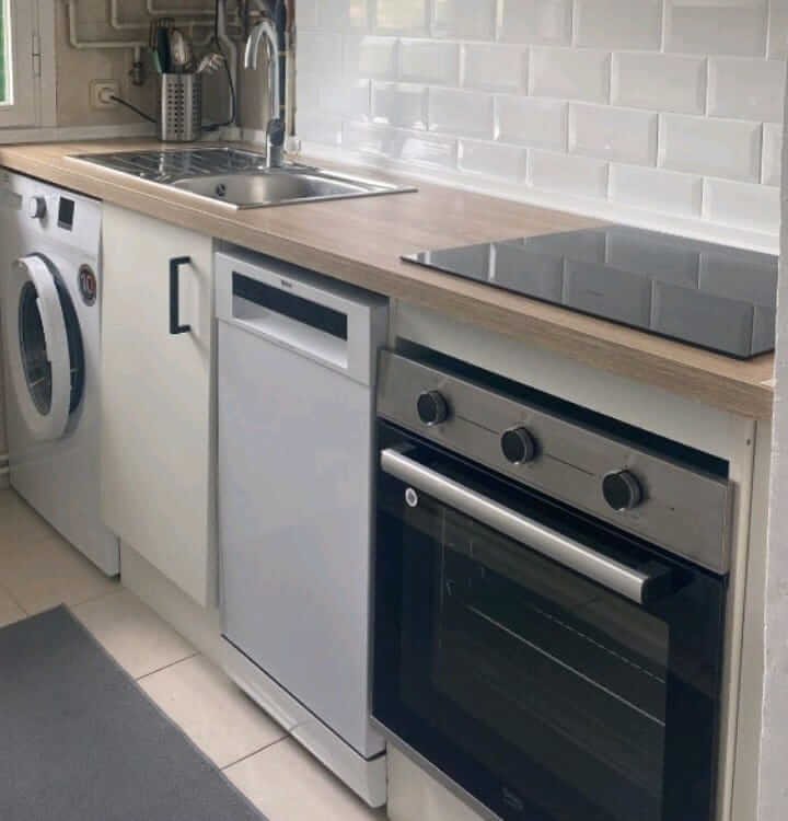Reforma de cocina moderna en Carrer de Sant Joan, Reus, con encimera de madera y electrodomésticos integrados.