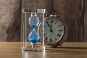 Reloj de arena y reloj ilustrando los plazos de licencia y obra en Reus y Tarragona
