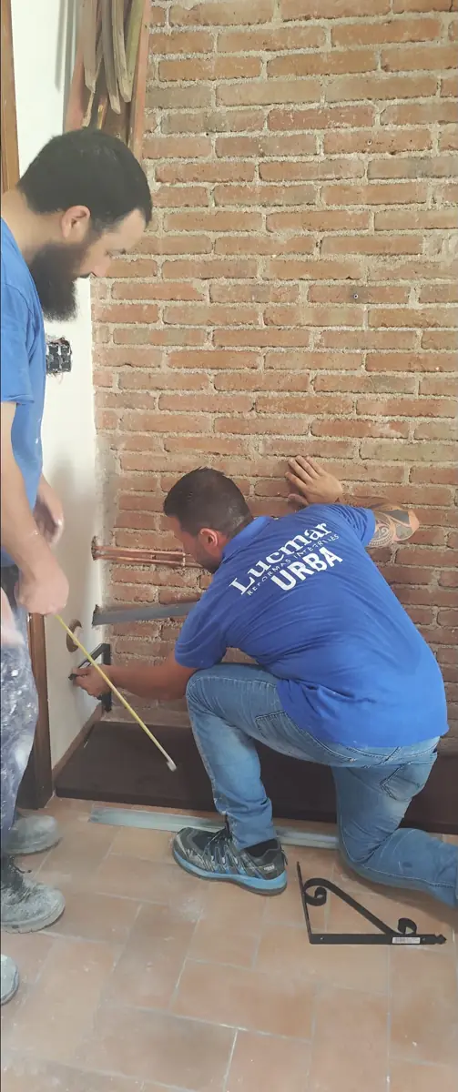 Equipo de LUCMAR URBA midiendo e instalando junto a una pared de ladrillo visto – LUCMAR